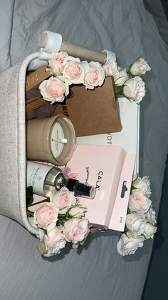 an arrangement of cosmetics and flowers on a bed