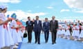 Xi Jinping waves to crowd of children holding flags as he walks with Kassym-Jomart Tokayev