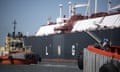 A large tanker with two tugboats.