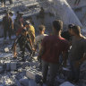 Palestinians search for bodies and survivors in the rubble of a residential building destroyed in an Israeli airstrike in Khan Younis.