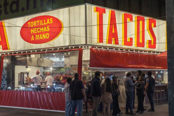 Customers line up outside La Chula taquería in Roma Sur, one of the Mexico City neighbourhoods that has become popular among tourists and international transplants.  