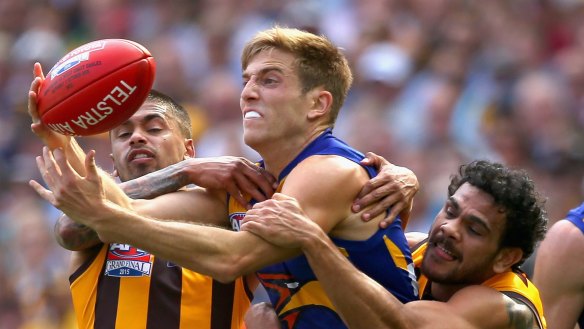 MELBOURNE, AUSTRALIA - OCTOBER 03:  Brad Sheppard of the Eagles handballs whilst being tackled by Bradley Hill and Cyril Rioli of the Hawks  during the 2015 AFL Grand Final match between the Hawthorn Hawks and the West Coast Eagles at Melbourne Cricket Ground on October 3, 2015 in Melbourne, Australia.  (Photo by Quinn Rooney/Getty Images)