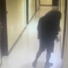 A man, who police identified as a suspect, walks along a hallway before entering a room at the hotel.