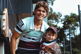 North Devils under-6s player Oscar White, the 200,000th player registered to play rugby league in Australia in 2024, with Brisbane Broncos fullback Reece Walsh.