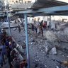 Palestinians look at the aftermath of the Israeli airstrike on a UN-run school that killed dozens of people in the Nusseirat refugee camp in the Gaza Strip.