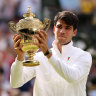 Carlos Alcaraz of Spain poses with the trophy after retaining his Wimbledon title.