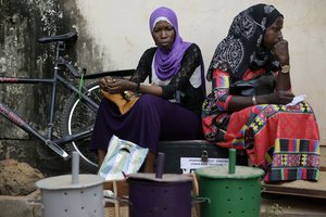 Women sit as they wait outside an independent electoral commission office where election material is being distributed in Banjul, Gambia, Tuesday Nov. 29, 2016.