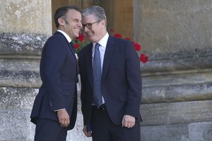 Britain's Prime Minister Sir Keir Starmer, right, greets France's President Emmanuel Macron as he arrives to attend the European Political Community summit at Blenheim Palace in Woodstock, Oxfordshire, England, Thursday July 18, 2024.