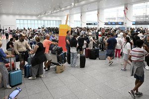 Travelers stand in a line at Brussels International Airport in Brussels, Friday, July 19, 2024. A global technology outage grounded flights, knocked banks and hospital systems offline and media outlets off air on Friday in a massive disruption that affected companies and services around the world and highlighted dependence on software from a handful of providers.