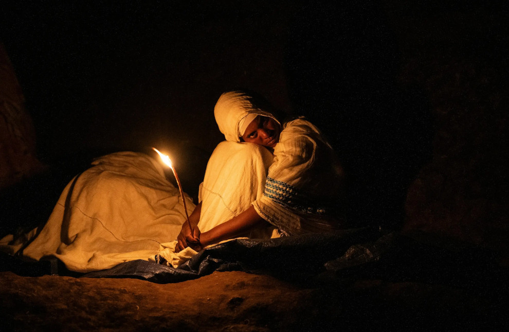 A girl holds a candle during a ceremony for Orthodox Easter in Addis Ababa on 5 May 2024. While Ethiopia is considered a regional leader on abortion provision in East Africa, strong religious views in the country often clash with abortion rights. AMANUEL SILESHI