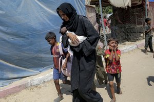 Palestinians evacuate from a site hit by an Israeli bombardment on Khan Younis, southern Gaza Strip, Saturday, July 13, 2024. Israel said it targeted Hamas' shadowy military commander in a massive strike Saturday in the crowded southern Gaza Strip that killed at least 71 people, according to local health officials. Hamas immediately rejected the claim that Mohammed Deif was targeted.