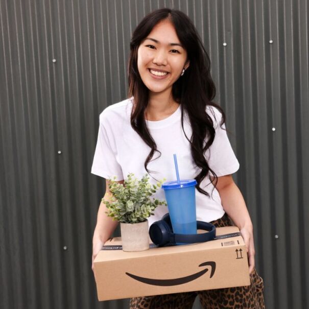 A woman holds an Amazon delivery box