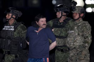 Joaquin "El Chapo" Guzman is made to face the press as he is escorted to a helicopter in handcuffs by Mexican soldiers and marines at a federal hangar in Mexico City, Mexico, Friday, Jan. 8, 2016.