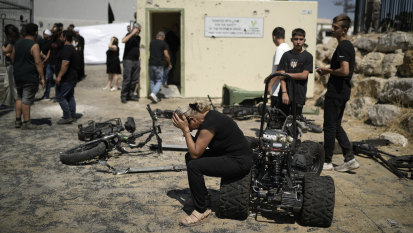 A woman from the Druze minority weeps near the site where 12 children and teens were killed in a rocket strike on a soccer field.