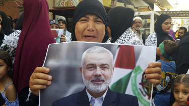 A Hamas supporter holds a poster of its political chief Ismail Haniyeh during a protest to condemn his killing.