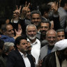 Hamas chief Ismail Haniyeh, centre, flashes a victory sign as he is surrounded by a group of Iranian MPs after the conclusion of the swearing-in ceremony of newly-elected Iranian President Masoud Pezeshkian.