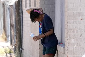 File - A person tries to cool off in the shade as temperatures are expected to hit 116-degrees Fahrenheit, Tuesday, July 18, 2023, in Phoenix. The extreme heat scorching Phoenix set a record Tuesday, the 19th consecutive day temperatures hit at least 110 degrees Fahrenheit.