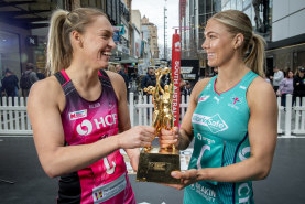 Adelaide Thunderbirds captain Hannah Petty and Melbourne Vixens counterpart Kate Moloney with the Super Netball trophy.