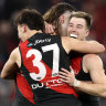 Essendon players celebrate on the fial siren.