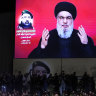 Hezbollah fighters stand behind the coffin of their top commander Fuad Shukr, who was killed by an Israeli airstrike as Hezbollah leader Sayyed Hassan Nasrallah speaks through a screen during Shukur’s funeral.