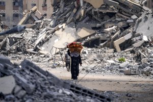 A Palestinian displaced woman by the Israeli air and ground offensive on the Gaza Strip flees from Hamad City, following an evacuation order by the Israeli army to leave parts of the southern area of Khan Younis, Sunday, Aug. 11, 2024.