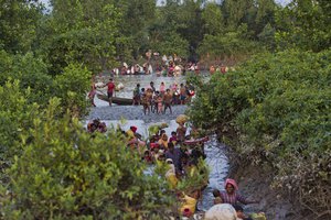 FILE - Groups of Rohingya Muslims cross the Naf river at the border between Myanmar and Bangladesh, near Palong Khali, Bangladesh, on  Nov. 1, 2017. At least 150 civilians from Myanmar’s Muslim Rohingya minority may have been killed this week in an artillery and drone attack in the western state of Rakhine that is being blamed on the Arakan Army, a major force in the resistance to military rule.