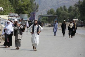 Afghans walk back after border crossing closed following firing between Pakistan and Afghan Taliban forces near Torkham, border of Nangarhar province, east of Kabul, Afghanistan, Tuesday, Aug. 13, 2024. Pakistani and Afghan Taliban forces traded cross-border fire near a key northwestern crossing, killing a woman and two children on the Afghan side of the border, officials said Tuesday. (AP Photo/Shafiullah Kakar)