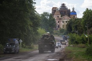 Military vehicles drive near the Russian-Ukrainian border in Sumy region, Ukraine, Tuesday, Aug. 13, 2024.