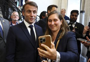 French President Emmanuel Macron poses with guests during the inauguration of the Maison Elysee, a museum and a shop opposite the Elysee Palace dedicated to the work of the French presidency, in Paris, France, July 24, 2024.