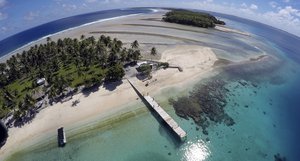 FILE - An aerial photo shows a small section of the atoll that has slipped beneath the water line only showing a small pile of rocks at low tide on Majuro Atoll in the Marshall Islands on Nov. 8, 2015.