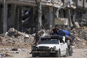 File - Palestinians evacuate Maghazi refugee camp in the central Gaza Strip, as part of a mass evacuation ordered by the Israeli military ahead of an operation, Saturday, Aug. 17, 2024.