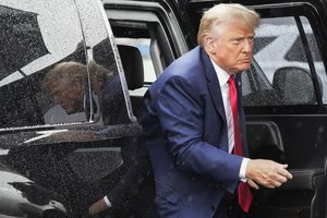 Former President Donald Trump arrives to board his plane at Ronald Reagan Washington National Airport, Thursday, Aug. 3, 2023, in Arlington