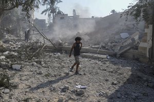 File - A Palestinian boy walks past the rubble of a school destroyed in an Israeli airstrike on Deir al-Balah, central Gaza Strip, Saturday, July 27, 2024.