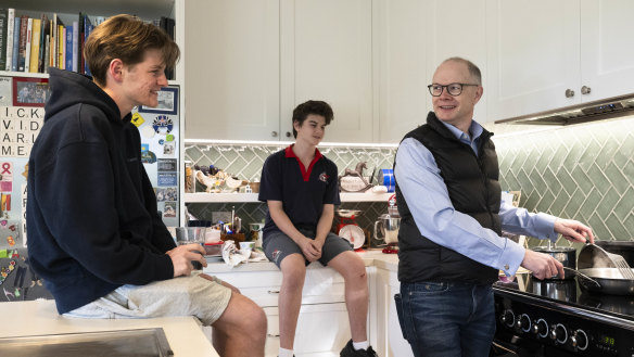 David McEwen with his sons, Charlie, left, and James in his Balgowlah home with his new induction cooktop. 