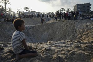 Palestinians look at the destruction after an Israeli airstrike on a crowded tent camp housing Palestinians displaced by the war in Muwasi, Gaza Strip, Tuesday, Sept. 10, 2024. An Israeli strike killed at least 40 people and wounded 60 others early Tuesday, Palestinian officials said. Israel said it targeted