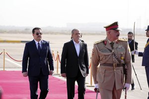 Iranian President Masoud Pezeshkian is welcomed by Iraqi Prime Minister Mohammed Shia al-Sudani, left, with an official ceremony at the Baghdad International Airport in Baghdad, Iraq, Wednesday Sept. 11, 2024