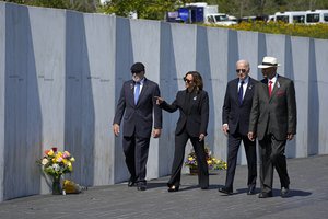 President Joe Biden, second from right, and Democratic presidential nominee Vice President Kamala Harris, second from left, walk with Flight 93 passengers family members Patrick White, cousin of Louis Nache, left, and Calvin Wilson, cousin of first officer Leroy Homer, right, after laying a wreath at the Wall of Names at the Flight 93 National Memorial in Shanksville, Pa., Wednesday, Sept. 11, 2024. (AP Photo/Gene J. Puskar)