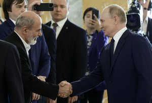 Russian President Vladimir Putin, right, and Iranian Supreme National Security Council Secretary Ali Akbar Ahmadian, left, shake hands during the BRICS and BRICS Plus High-Level Security Officials meeting in St. Petersburg, Russia, Thursday, Sept. 12, 2024.