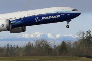 A Boeing 777X airplane takes off on its first flight with the Olympic Mountains in the background at Paine Field, Saturday, Jan. 25, 2020, in Everett, Wash.