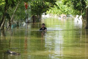 A man wades in chest deep flood in the aftermath of Typhoon Yagi in An Lac village, Hanoi, Vietnam  Friday, Sept. 13, 2024.