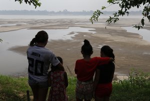 Residents look out at the Madeira River, a tributary of the Amazon River, during the dry season in Humaita, Amazonas state, Brazil, Saturday, Sept. 7, 2024.