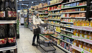 A customer checks prices while shopping at a grocery store in Wheeling, Illinois, on Jan. 19, 2024. (AP Photo/Nam Y. Huh)