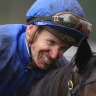 James McDonald grins through the mud after winning the Champagne Stakes on Broadsiding.