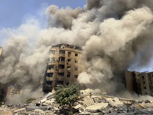 Smoke rises as a building collapses in Beirut's southern suburbs, Saturday, Sept. 28, 2024.