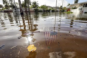 An American flag sits in floodwaters in the aftermath of Hurricane Helene in the Shore Acres neighborhood Friday, Sept. 27, 2024, in St. Petersburg, Fla.