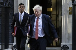 FILE - In this Tuesday, Sept. 1, 2020 file photo, Britain's Prime Minister Boris Johnson and Chancellor Rishi Sunak, left, leave Downing Street to attend a cabinet meeting in London.