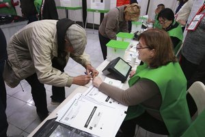 People get their ballots at a polling station during the parliamentary election in Tbilisi, Georgia, Saturday, Oct. 26, 2024.