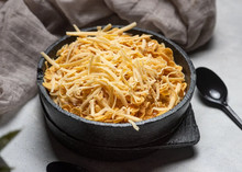 A bowl of cornflakes with grated Monterey Jack cheese