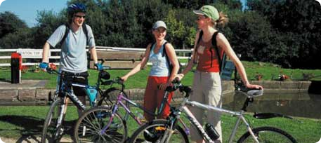 Three cyclists standing by bikes