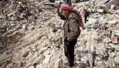 A Syrian man reacts while standing on the rubble of his house while others look for survivors and bodies in the Tariq al-Bab district of the northern city of Aleppo on February 23, 2013. Three surface-to-surface missiles fired by Syrian regime forces in Aleppo's Tariq al-Bab district have left 58 people dead, among them 36 children, the Syrian Observatory for Human Rights said on February 24. AFP PHOTO/PABLO TOSCO (Photo credit should read Pablo Tosco/AFP/Getty Images)